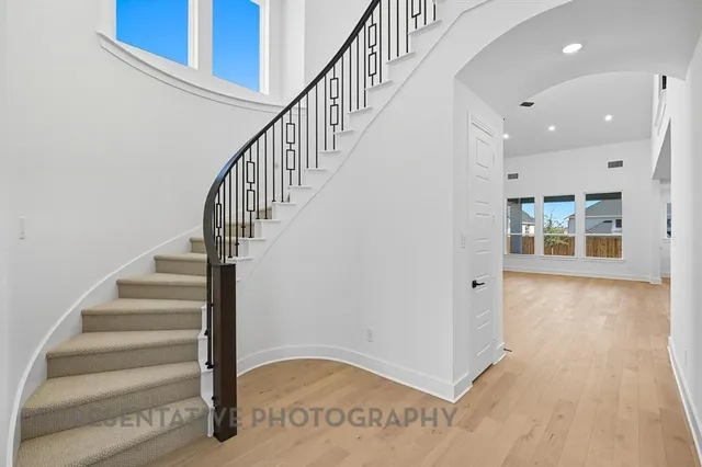 a large white kitchen with kitchen island a sink stainless steel appliances and cabinets