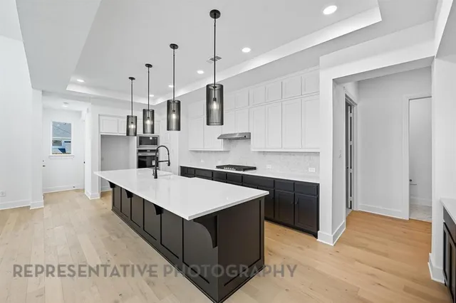 a large kitchen with stainless steel appliances kitchen island a cabinets and wooden floor
