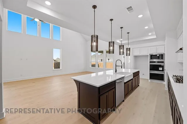 a large kitchen with kitchen island a sink a counter space and stainless steel appliances
