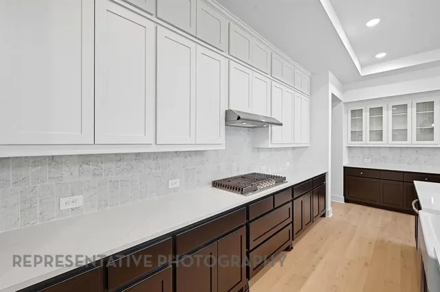 a large white kitchen with stainless steel appliances granite countertop a stove and a refrigerator
