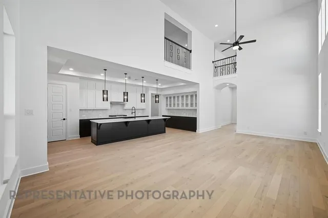 an empty room with windows and ceiling fan