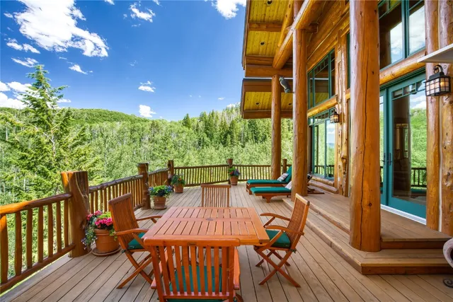 a view of a patio with table and chairs with wooden floor and fence