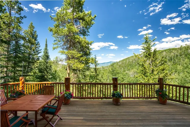 a balcony with wooden floor table and chairs