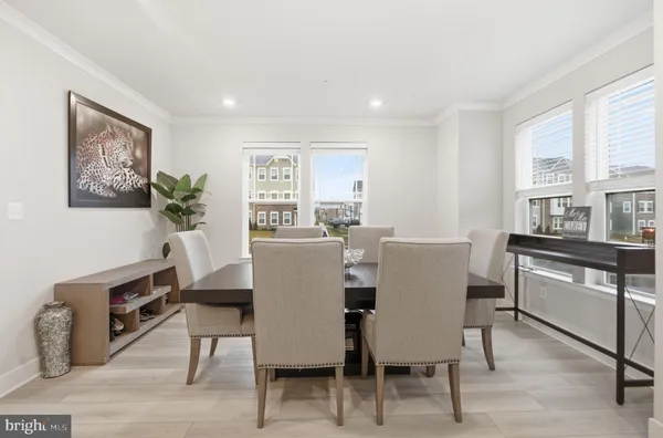 a kitchen with a table chairs a sink dishwasher refrigerator and cabinets