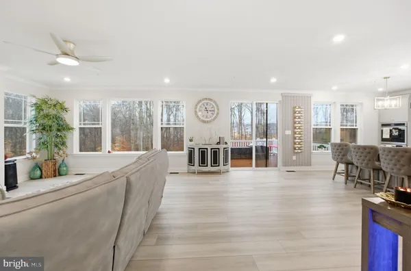 a open kitchen with stainless steel appliances granite countertop a refrigerator a sink dishwasher a dining table and chairs with wooden floor