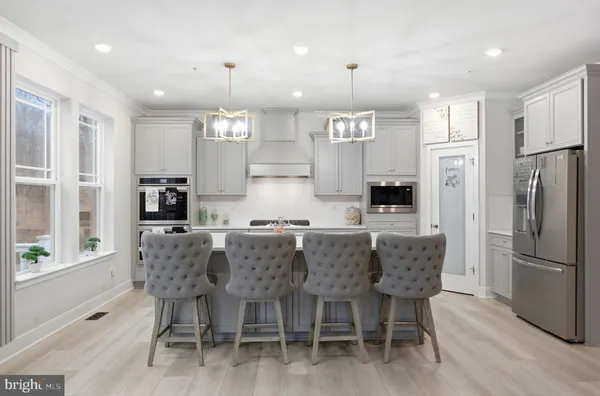 a kitchen with stainless steel appliances kitchen island granite countertop a table chairs and a refrigerator