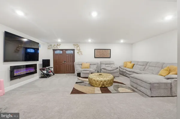 a living room with furniture a flat screen tv and gym equipment