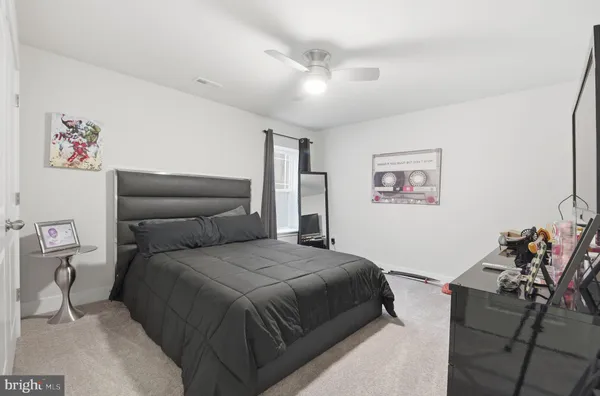 a spacious bedroom with a large bed and a flat tv screen