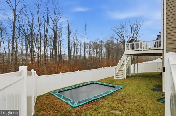 a view of a roof deck with two couches next to a yard