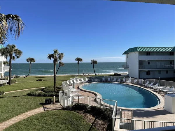 a view of a swimming pool with lawn chairs