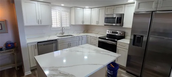 a kitchen with a sink a microwave and refrigerator