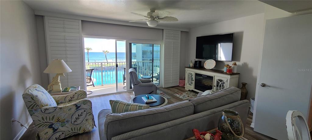 815 Ocean Shore Boulevard, Unit 7B Ormond Beach, FL 32176 - Photo 4 of 19 a living room with furniture and a fireplace