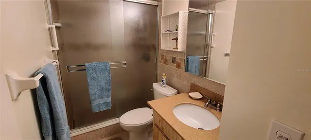 a bathroom with a granite countertop toilet and a sink