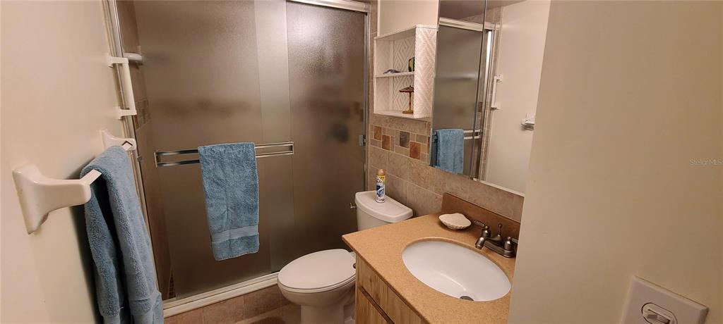 815 Ocean Shore Boulevard, Unit 7B Ormond Beach, FL 32176 - Photo 5 of 19 a bathroom with a granite countertop toilet and a sink