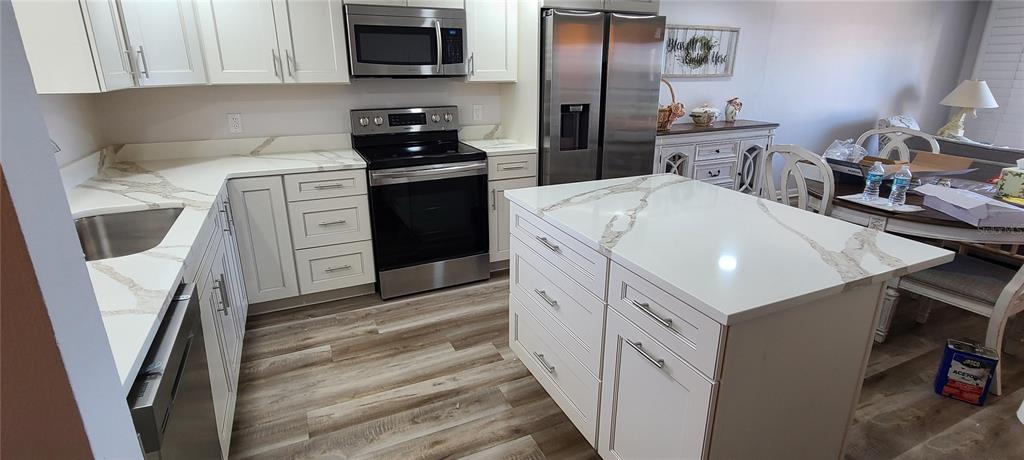 815 Ocean Shore Boulevard, Unit 7B Ormond Beach, FL 32176 - Photo 9 of 19 a kitchen with stainless steel appliances a white cabinets and a sink