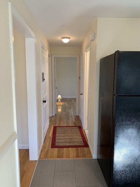 18 Guernsey Street, Unit 2 Marblehead, MA 01945 - Photo 14 of 23 a view of a hallway with wooden floor and a bathroom