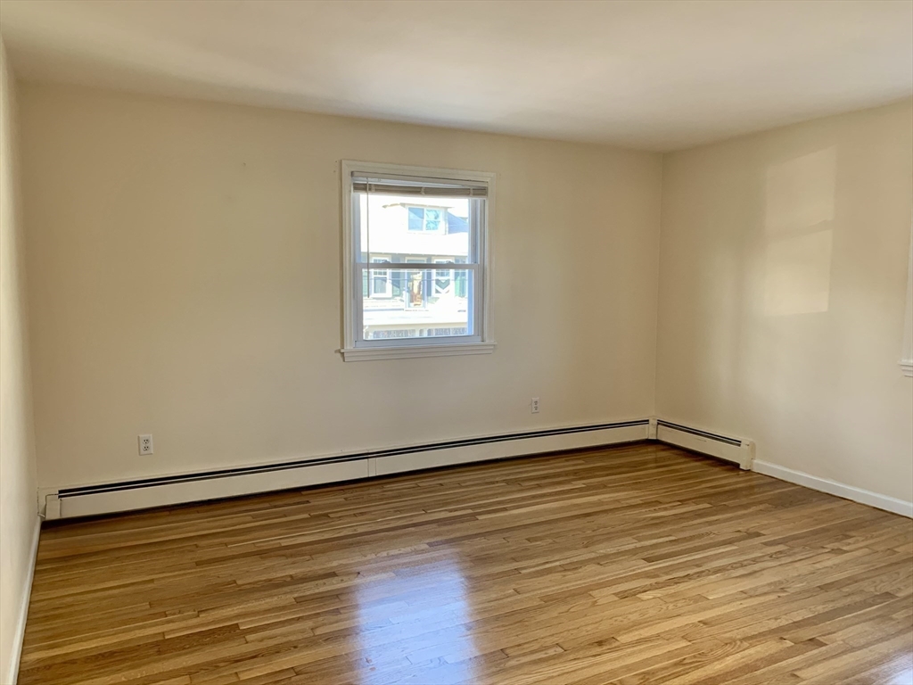 18 Guernsey Street, Unit 2 Marblehead, MA 01945 - Photo 15 of 23 a view of an empty room with wooden floor and a window