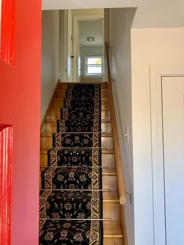 a view of a hallway with wooden floor and windows
