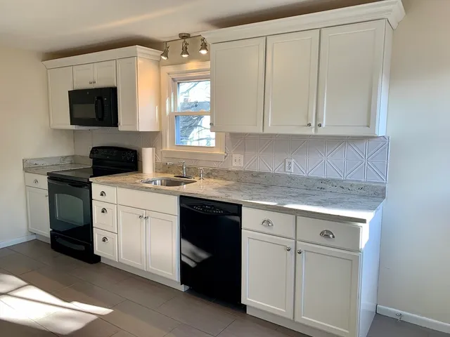 a kitchen with white cabinets and a sink