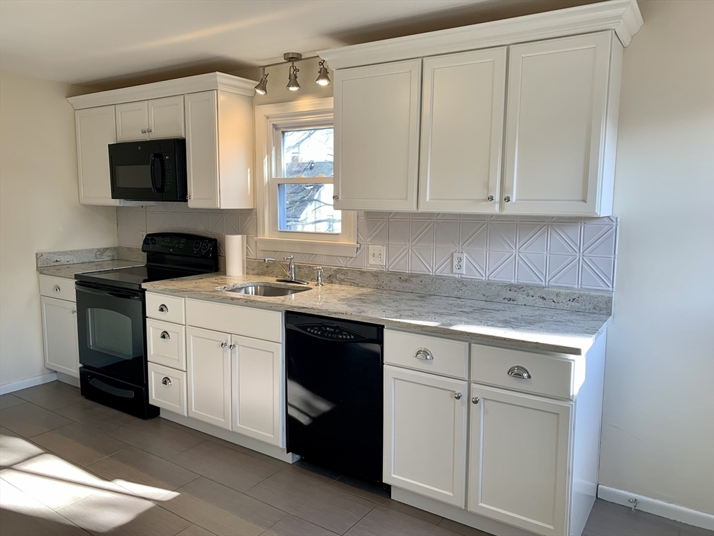 18 Guernsey Street, Unit 2 Marblehead, MA 01945 - Photo 5 of 23 a kitchen with white cabinets and a sink