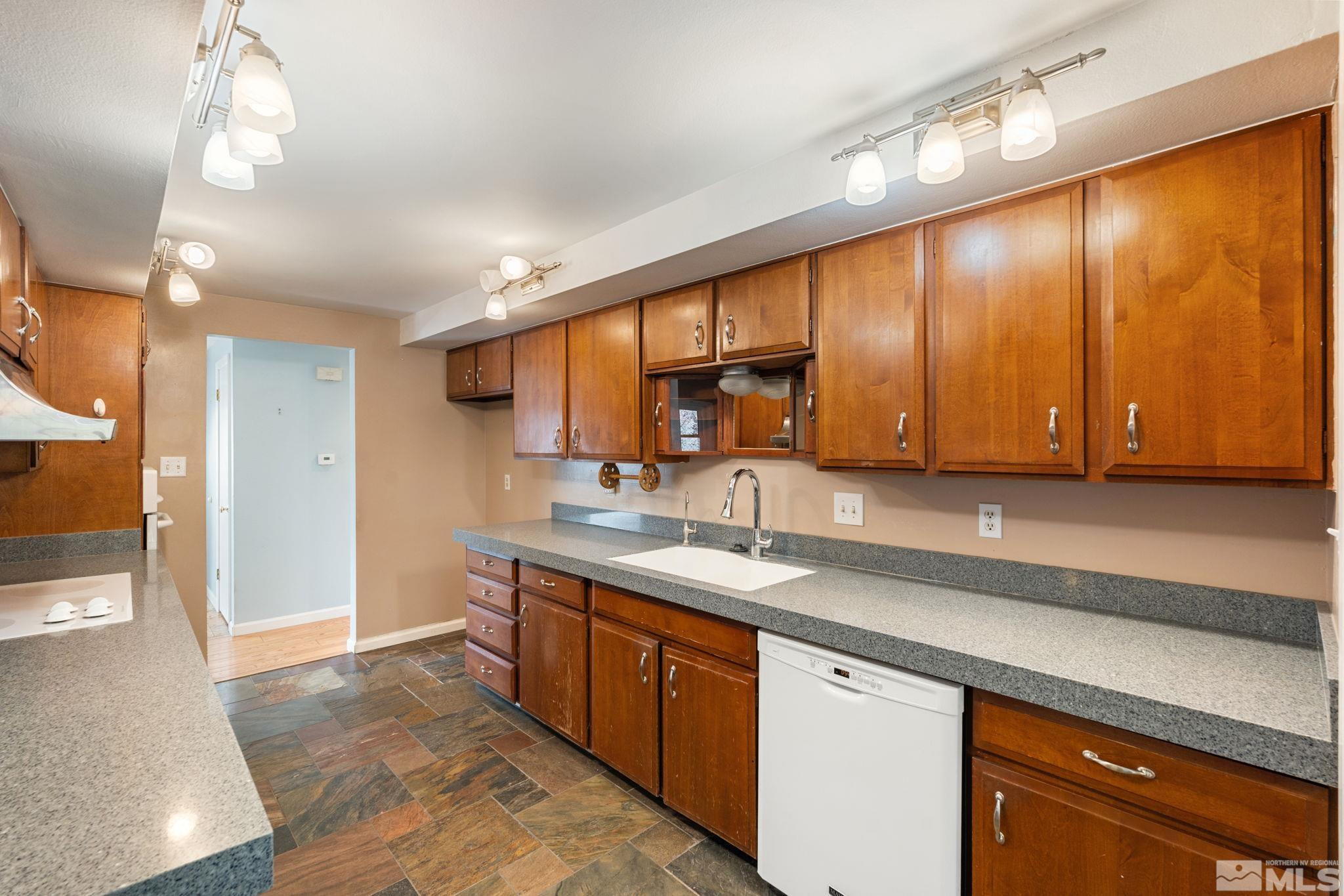 3325 Norman Drive Reno, NV 89509 - Photo 20 of 40 a kitchen with stainless steel appliances granite countertop a sink a stove cabinets and entryway with wooden floor