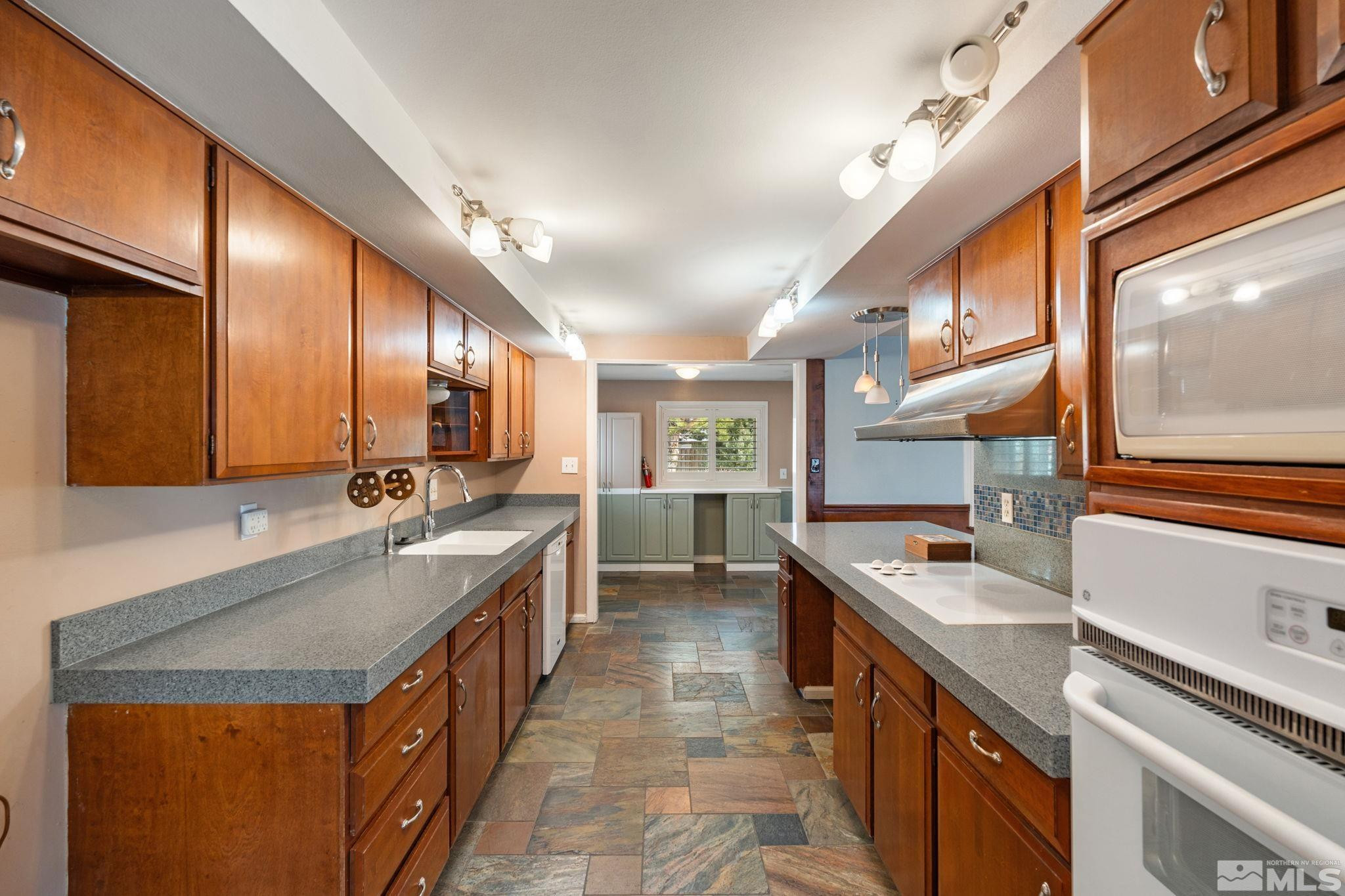 3325 Norman Drive Reno, NV 89509 - Photo 21 of 40 a kitchen with stainless steel appliances granite countertop counter top space a sink and cabinets