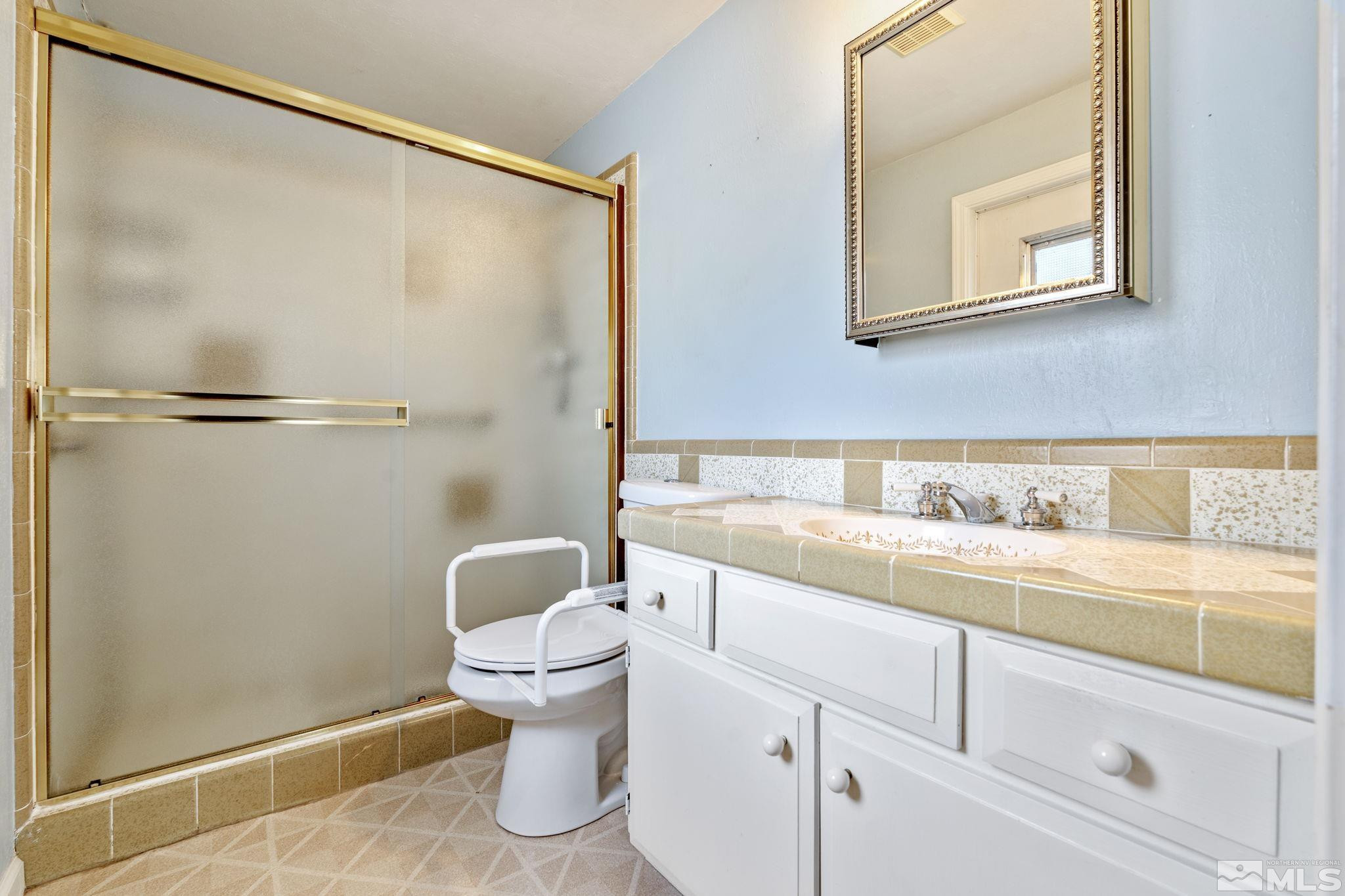 3325 Norman Drive Reno, NV 89509 - Photo 29 of 40 a bathroom with a granite countertop sink toilet and a shower