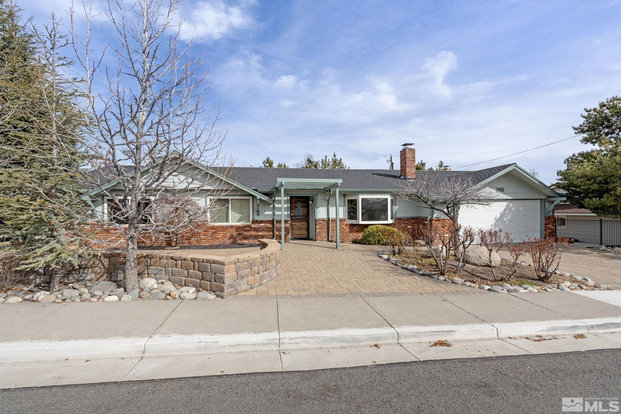 3325 Norman Drive Reno, NV 89509 - Photo 5 of 40 a view of a white house next to a yard with big trees
