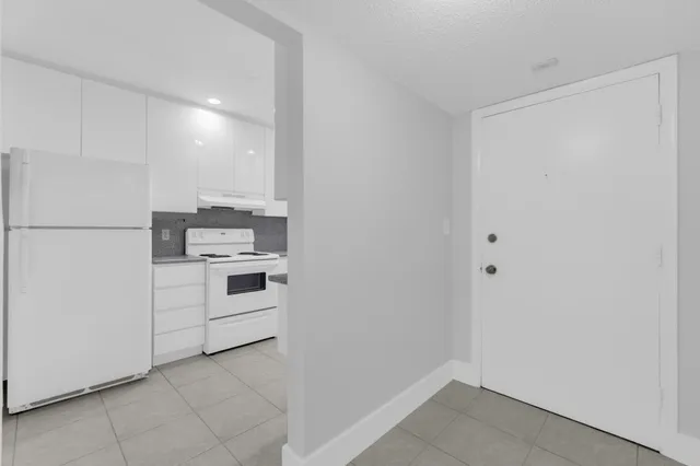 a kitchen with white cabinets and white appliances