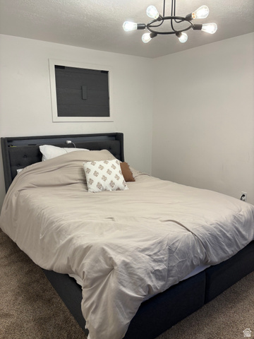 545 23rd Street Ogden, UT 84401 - Photo 28 of 28 Spacious room featuring neutral carpeting, a window with dark blinds, and a modern industrial-style chandelier