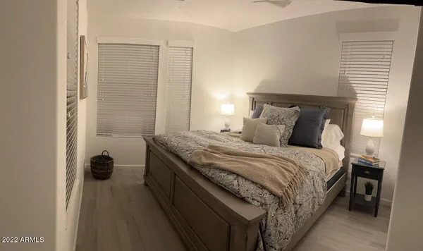 a bedroom with a bed and a lamp on the dresser
