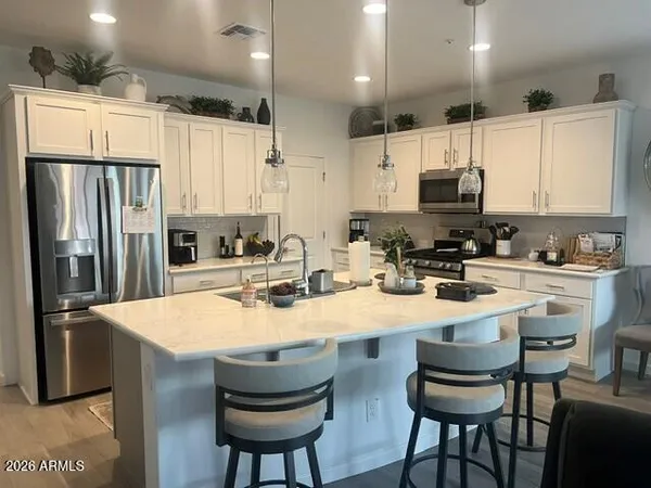 a kitchen with kitchen island a appliances and a refrigerator