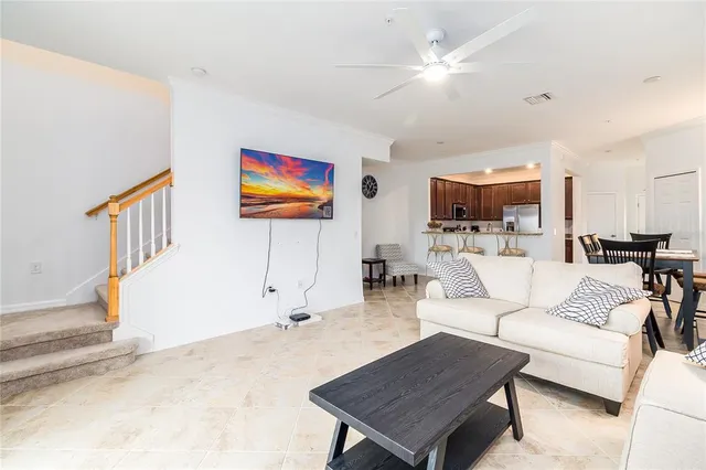 a living room with furniture kitchen view and a flat screen tv