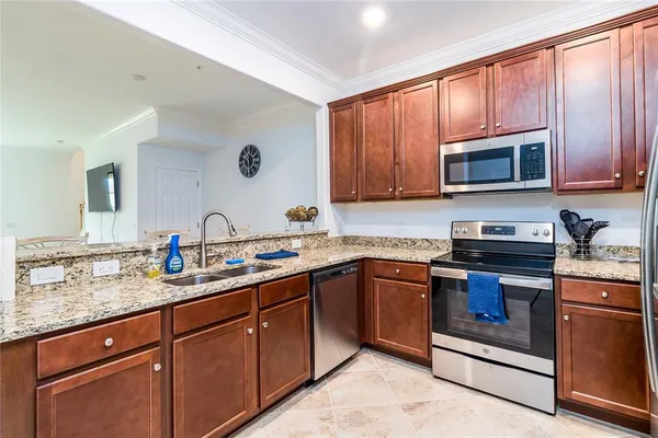 a kitchen with stainless steel appliances granite countertop wooden cabinets stove top oven and microwave