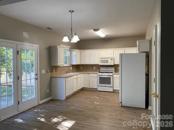 a kitchen with a refrigerator a stove a sink and a window