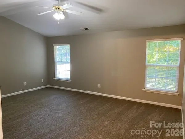 an empty room with a window and a fan