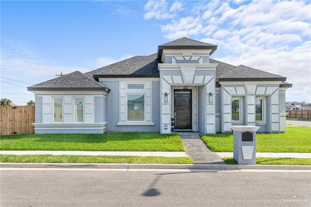 a view of a house with a big yard plants and large trees