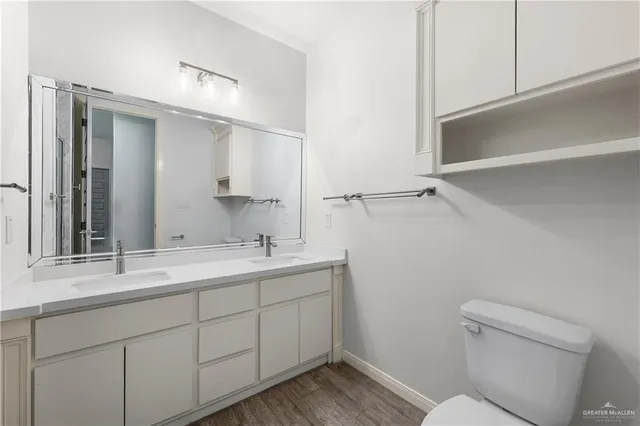 a bathroom with a sink a toilet a mirror and vanity