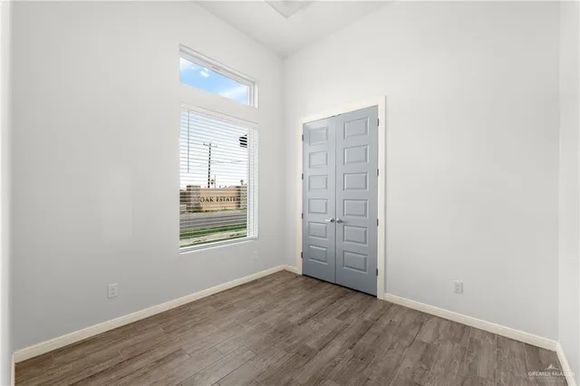 an empty room with windows and closet