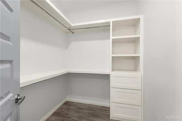 a view of walk in closet with empty racks