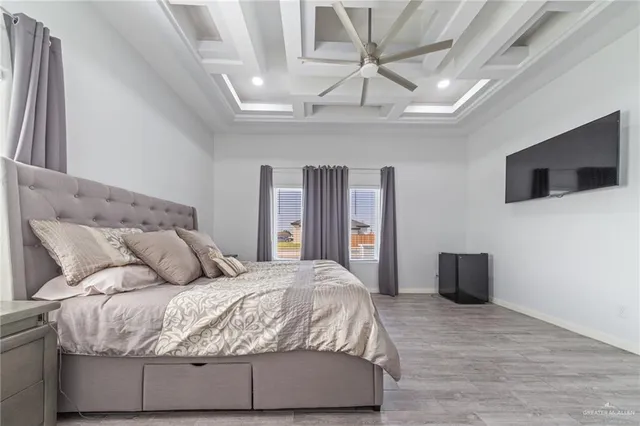 a bedroom with a large bed and a flat tv screen on dresser