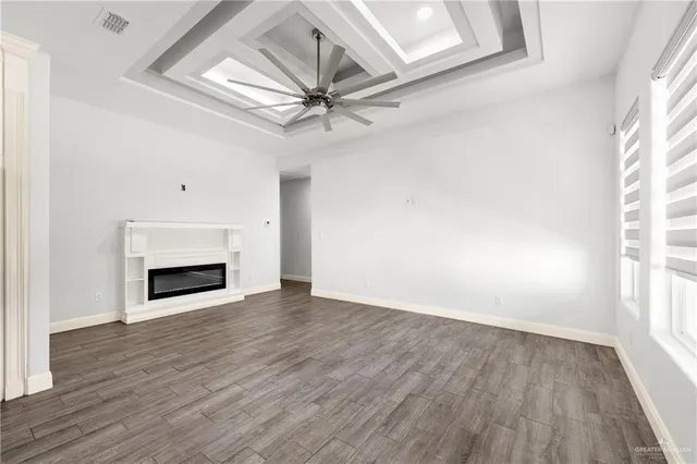 wooden floor fireplace and windows in an empty room