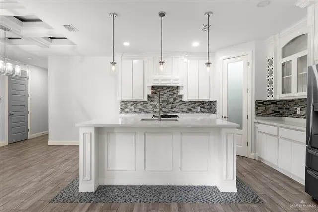 a kitchen with kitchen island a counter top space a sink stainless steel appliances and cabinets