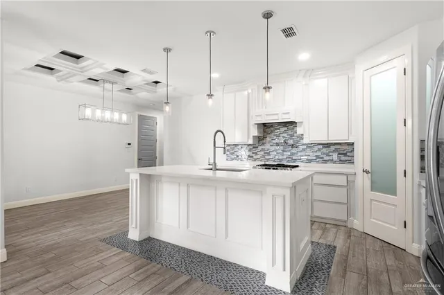 a kitchen with white cabinets and sink