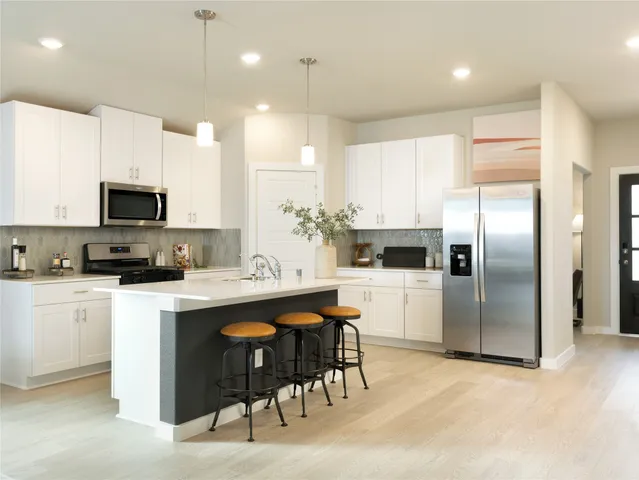 a kitchen with kitchen island a appliances a center island cabinets and a counter top space