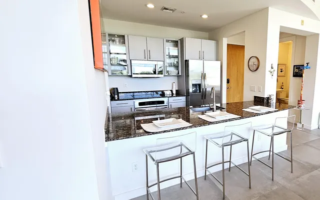 a kitchen with stainless steel appliances kitchen island granite countertop a refrigerator and a stove top oven