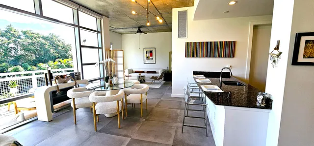 a living room with furniture a flat screen tv and a large window