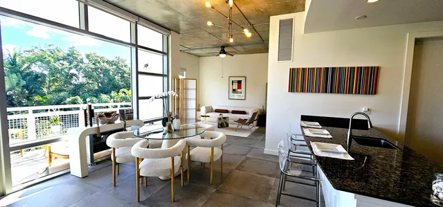 a dining room with furniture a chandelier and wooden floor