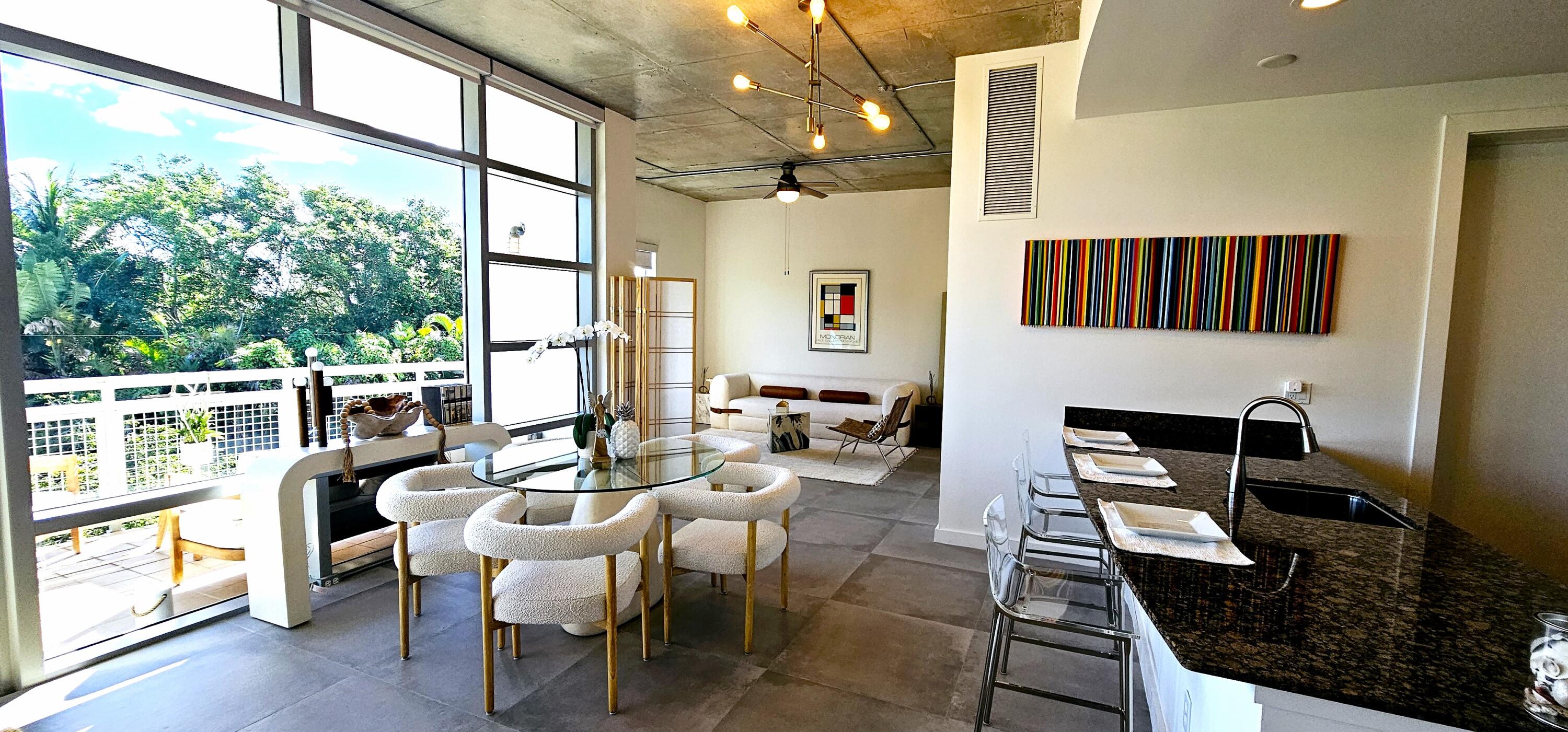 365 Southeast 6th Avenue, Unit 305 Delray Beach, FL 33483 - Photo 15 of 49 a dining room with furniture a chandelier and wooden floor