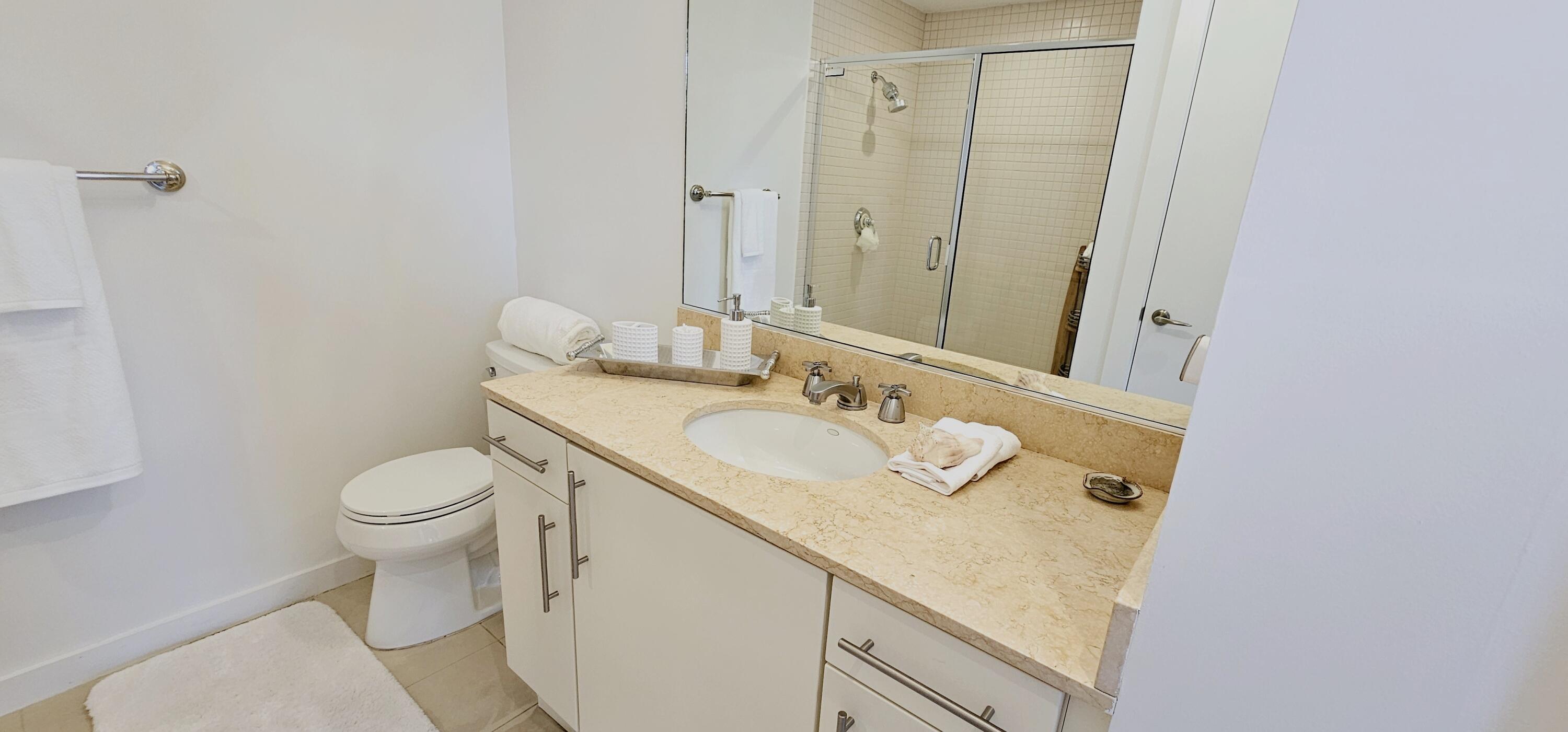 365 Southeast 6th Avenue, Unit 305 Delray Beach, FL 33483 - Photo 42 of 49 a bathroom with a granite countertop sink toilet and shower